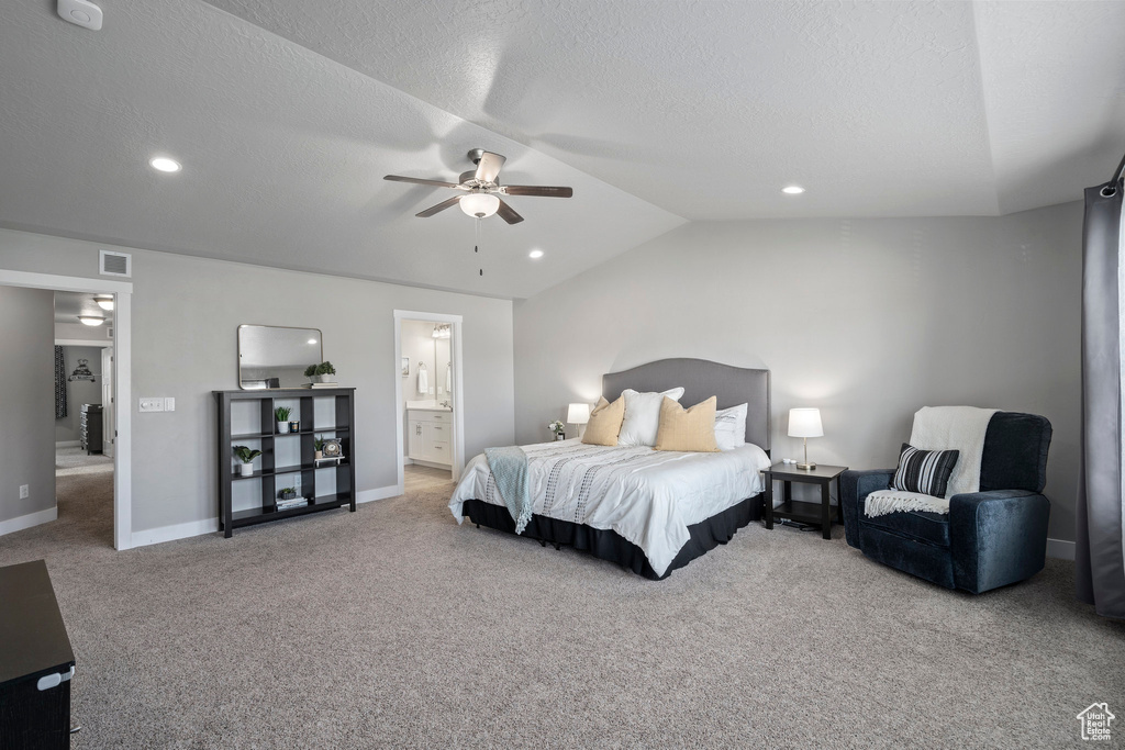 Carpeted bedroom featuring connected bathroom, ceiling fan, lofted ceiling, and a textured ceiling