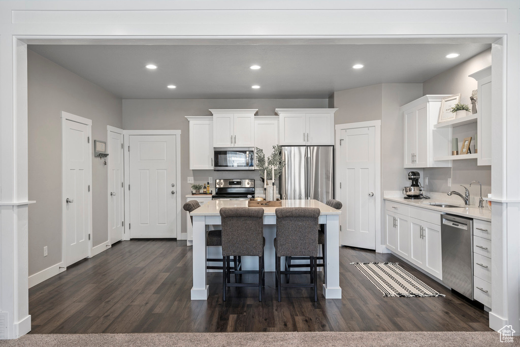 Kitchen with appliances with stainless steel finishes, dark wood-type flooring, and white cabinets
