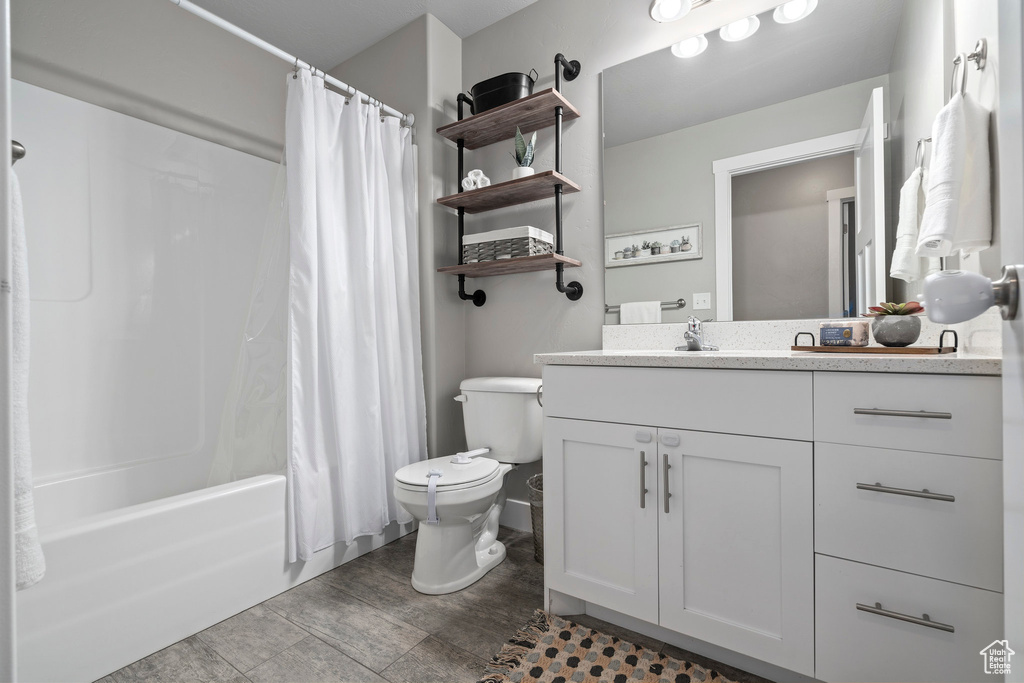 Full bathroom with shower / bath combo, vanity, toilet, and tile flooring