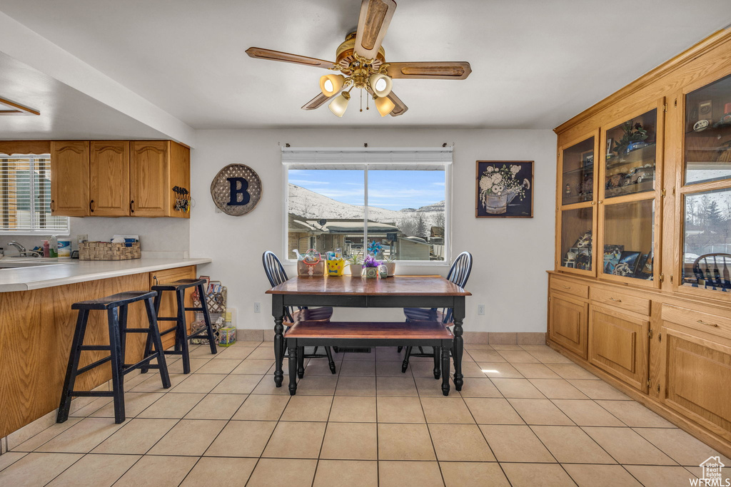 Dining space with plenty of natural light, ceiling fan, and light tile floors