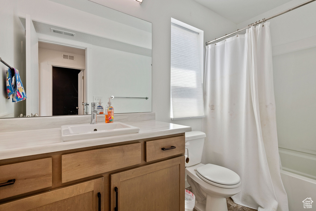Full bathroom with shower / bath combo, toilet, and oversized vanity