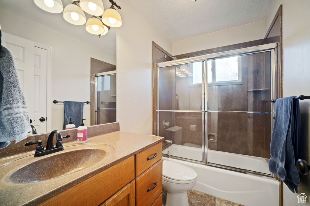 Full bathroom with oversized vanity, toilet, enclosed tub / shower combo, and tile flooring