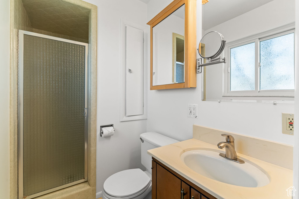 Bathroom with walk in shower, large vanity, and toilet