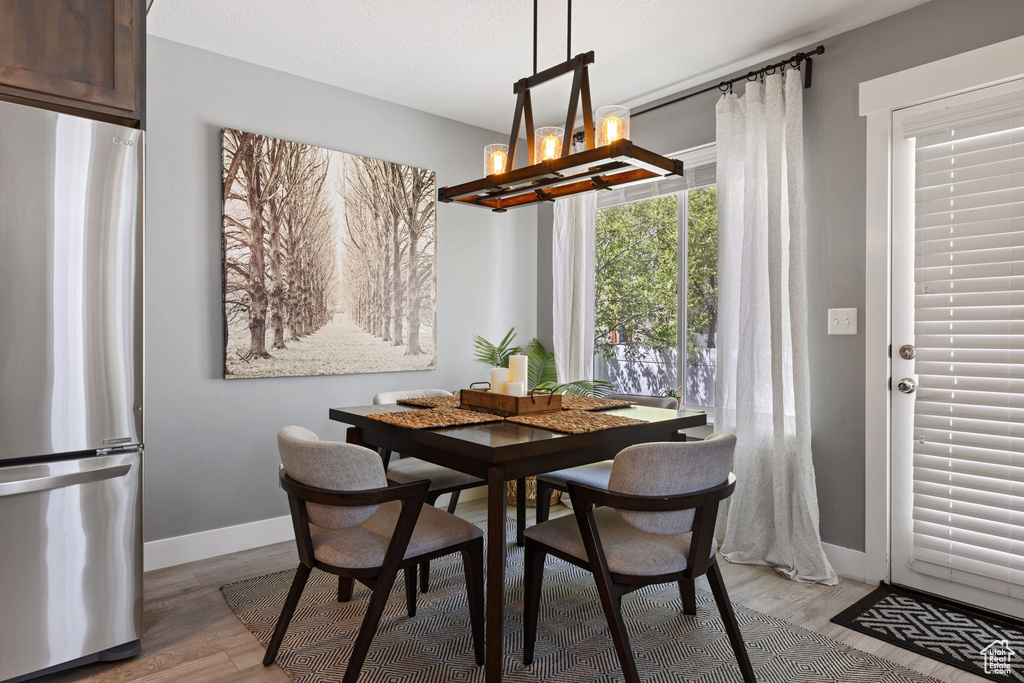 Dining area with hardwood / wood-style flooring and an inviting chandelier