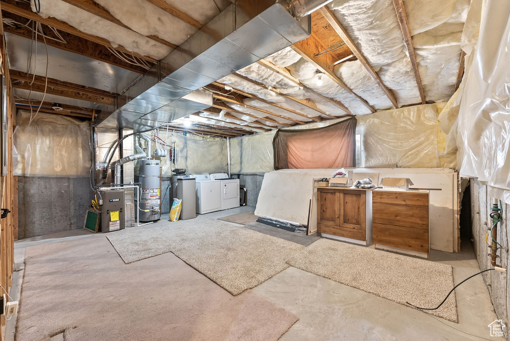 Basement featuring water heater and washer and clothes dryer