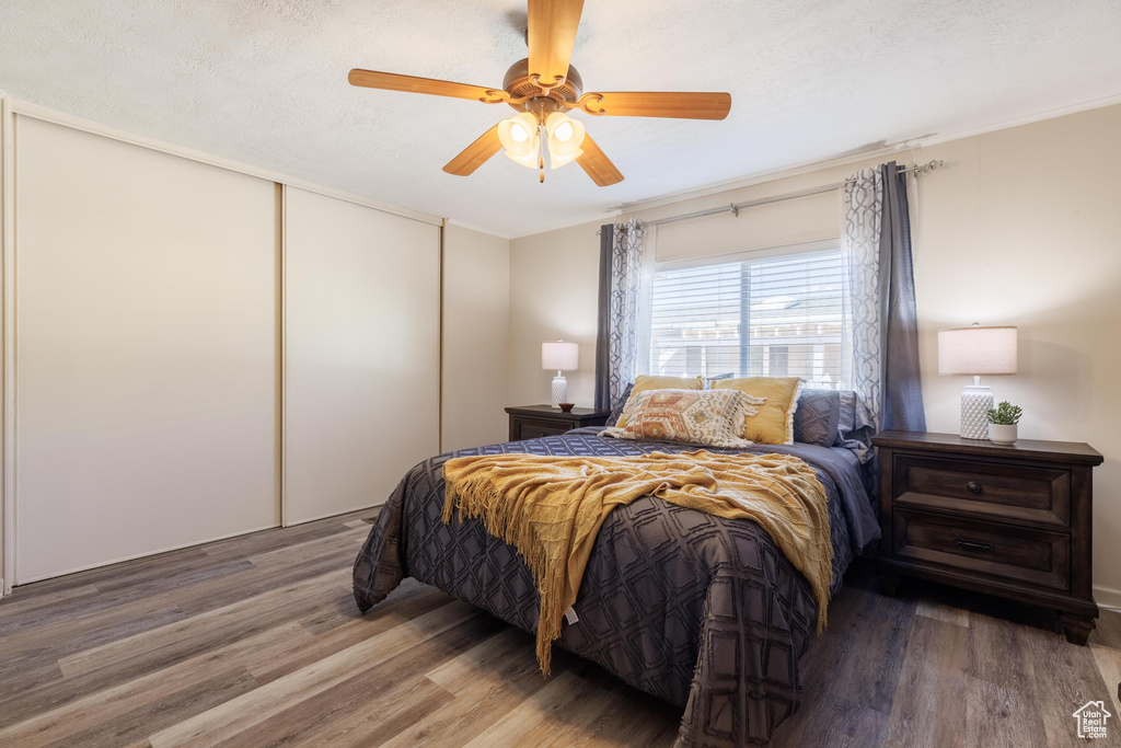 Bedroom featuring hardwood / wood-style floors, a closet, and ceiling fan