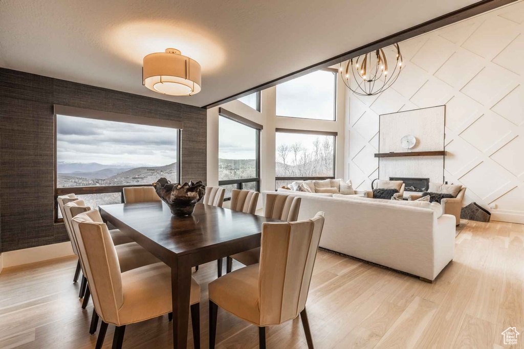 Dining area with a mountain view, an inviting chandelier, and light hardwood / wood-style flooring