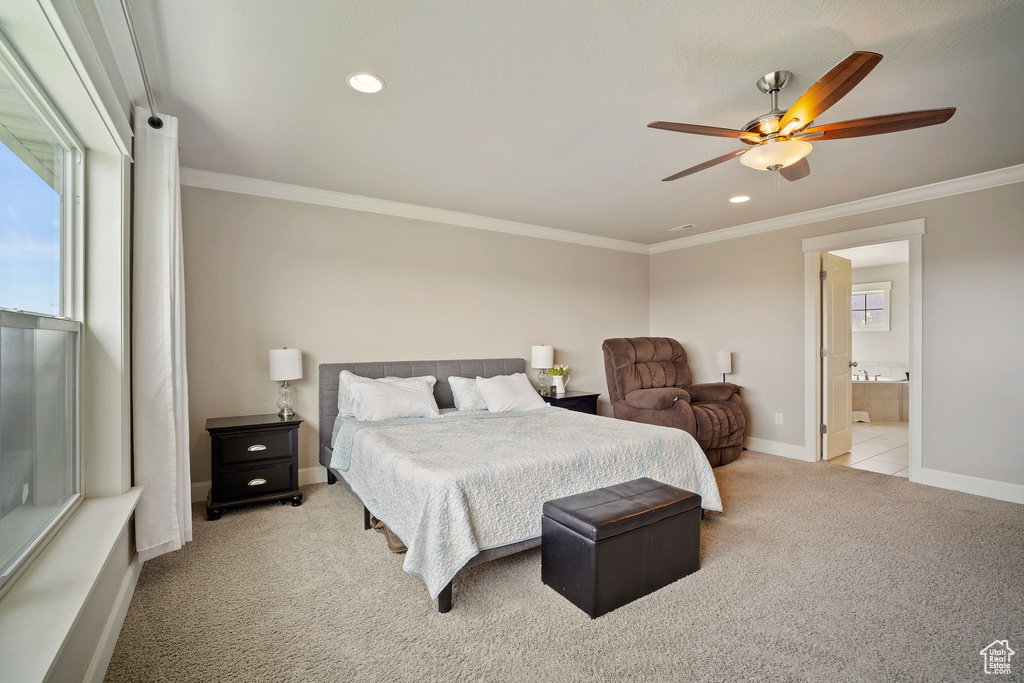Carpeted bedroom featuring crown molding, ensuite bath, ceiling fan, and multiple windows
