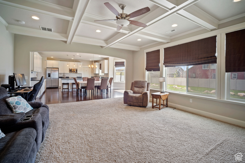 Living room featuring carpet, crown molding, and coffered ceiling