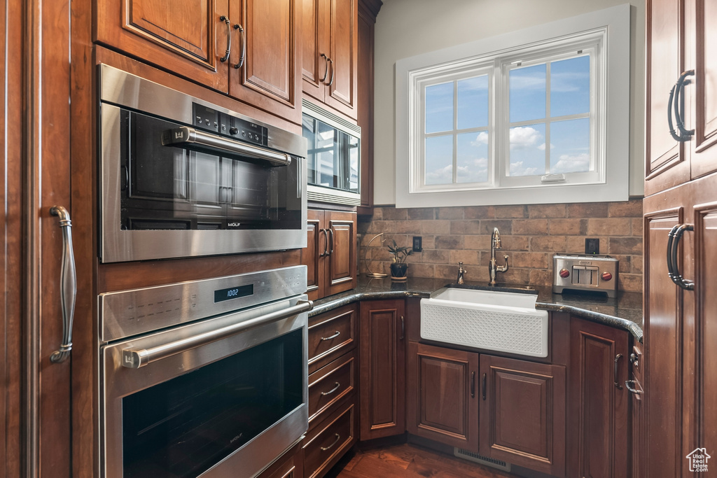 Kitchen featuring stainless steel microwave, sink, tasteful backsplash, and a wealth of natural light