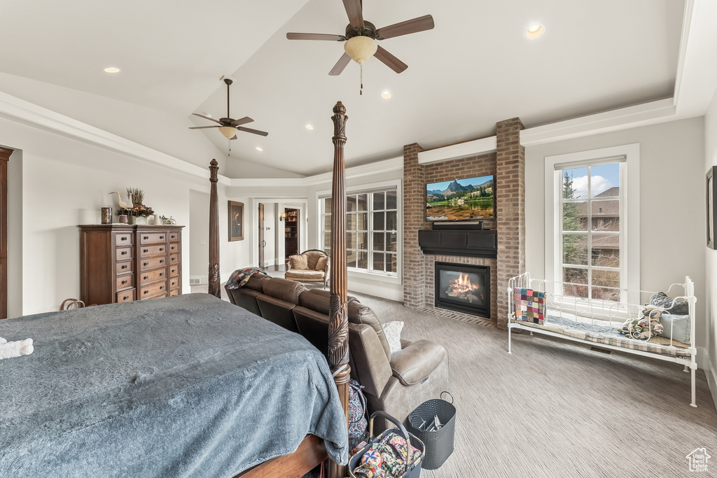 Bedroom featuring carpet, a brick fireplace, brick wall, vaulted ceiling, and ceiling fan