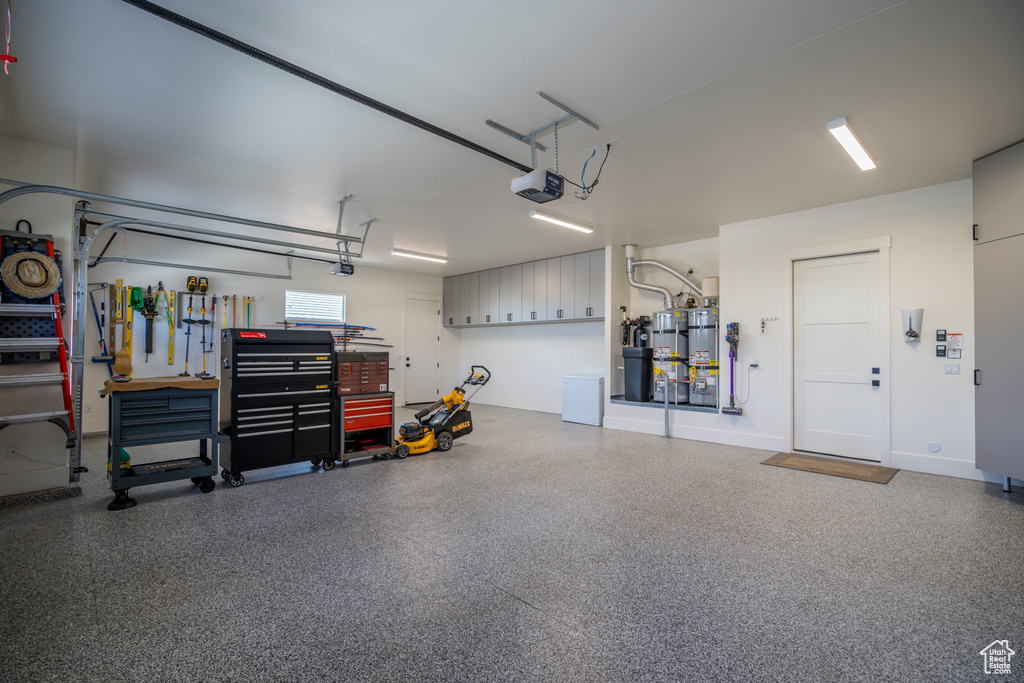 Garage featuring strapped water heater and a garage door opener