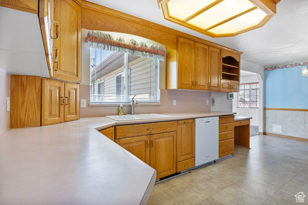 Kitchen with plenty of natural light, sink, white dishwasher, and light tile floors