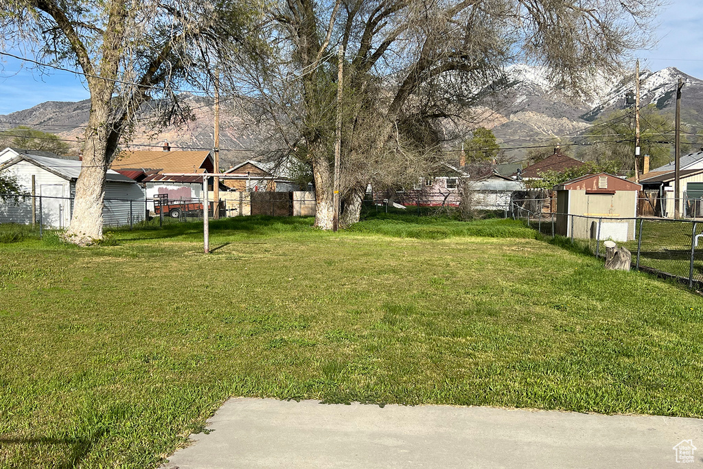 View of yard featuring a mountain view and a storage unit