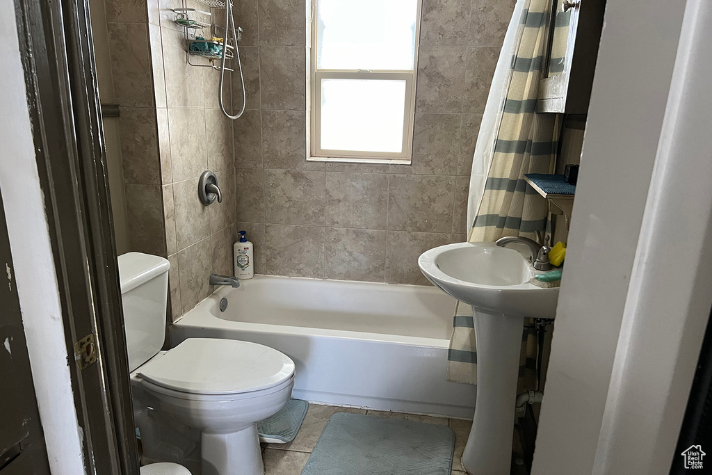 Bathroom with shower / bath combination with curtain, toilet, and tile flooring