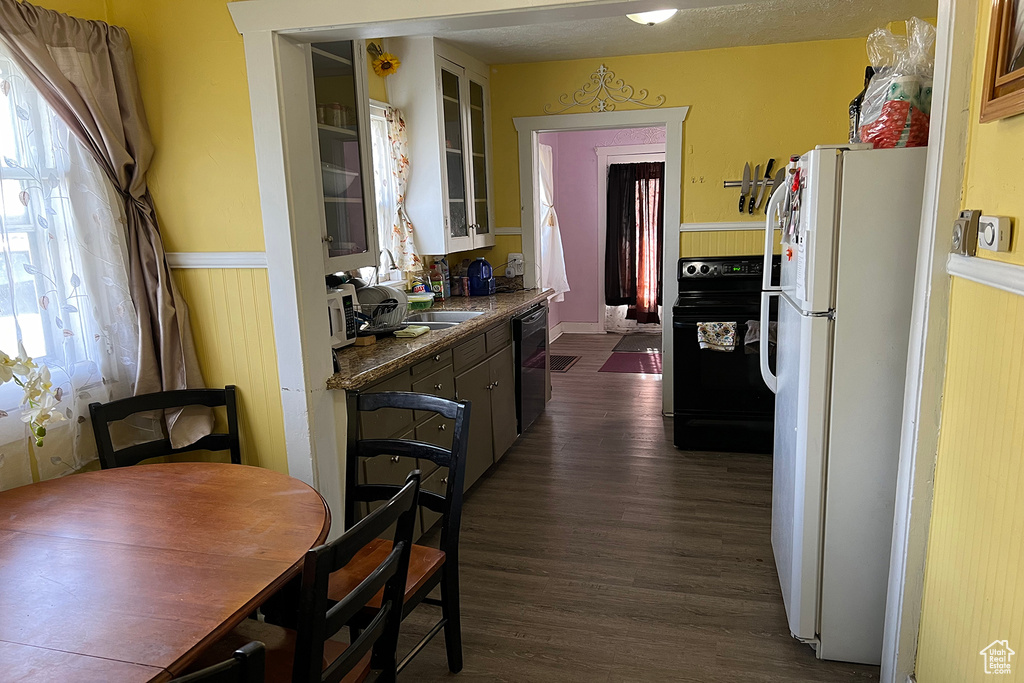 Kitchen with electric range, dark hardwood / wood-style flooring, white fridge, and dishwasher
