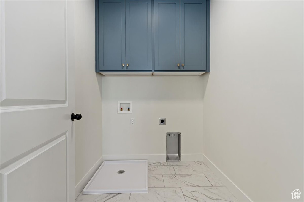 Laundry area with washer hookup, electric dryer hookup, cabinets, and light tile floors