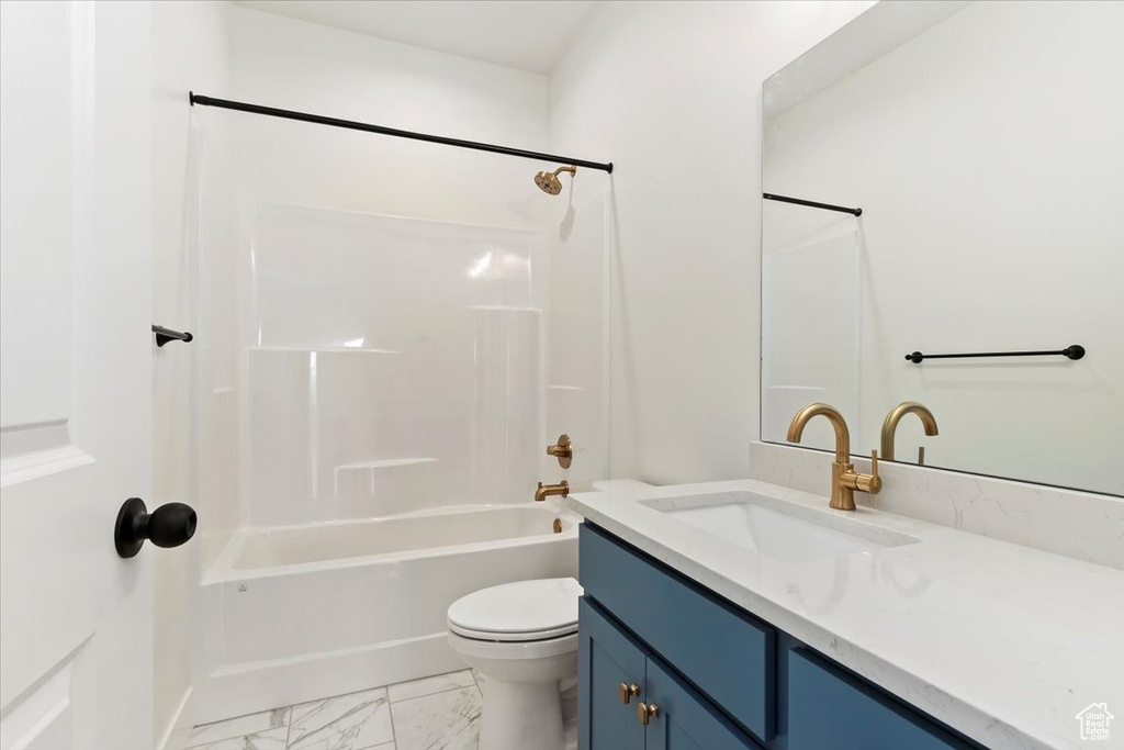 Full bathroom featuring vanity with extensive cabinet space, tile floors, tub / shower combination, and toilet
