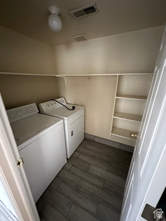 Laundry room featuring dark wood-type flooring and washer and dryer
