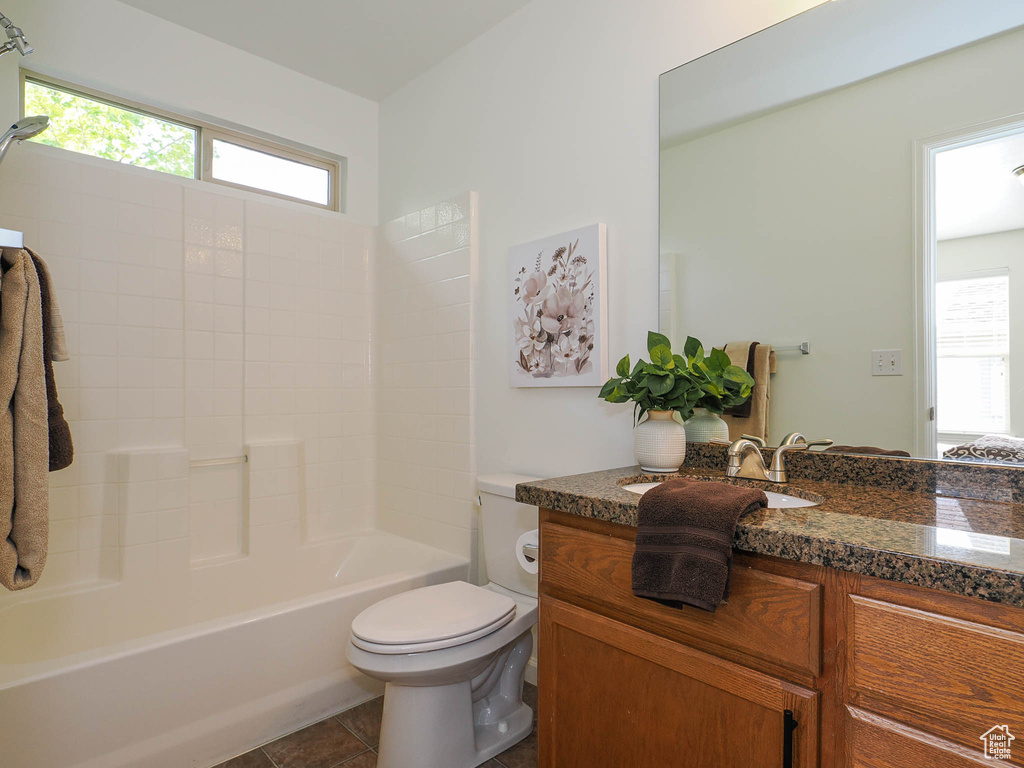 Full bathroom featuring bathtub / shower combination, vanity, toilet, and tile flooring