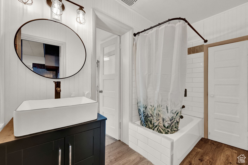 Bathroom featuring shower / tub combo with curtain, vanity, and hardwood / wood-style floors