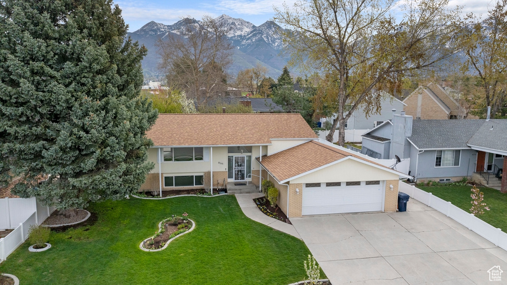 Split foyer home featuring a mountain view, a garage, and a front yard