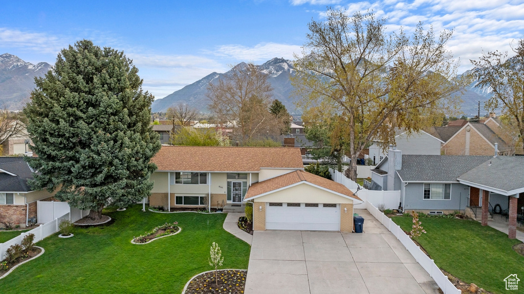 Split foyer home with a front yard, a mountain view, and a garage