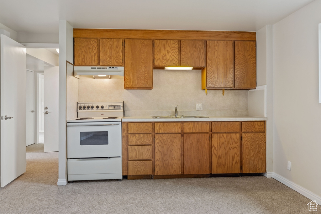 Kitchen featuring light colored carpet, sink, and electric range