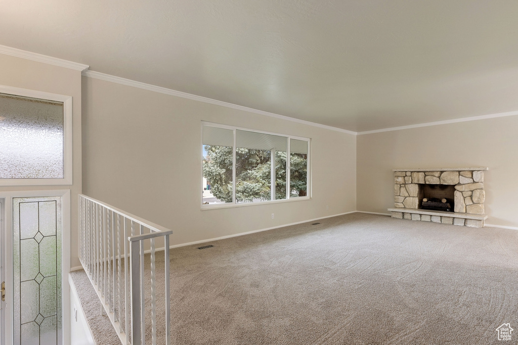 Interior space featuring a fireplace, carpet floors, and ornamental molding