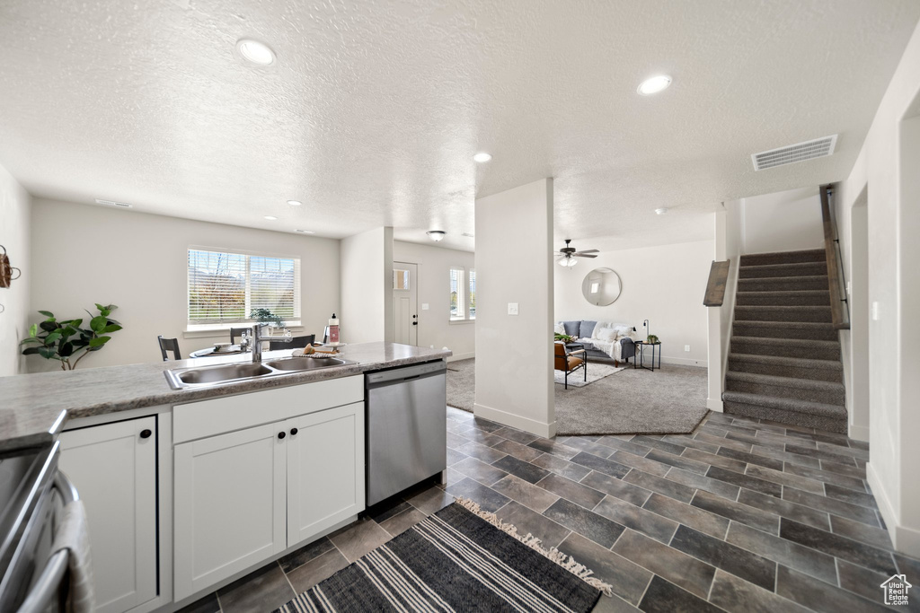 Kitchen featuring ceiling fan, dishwasher, dark tile flooring, range, and sink