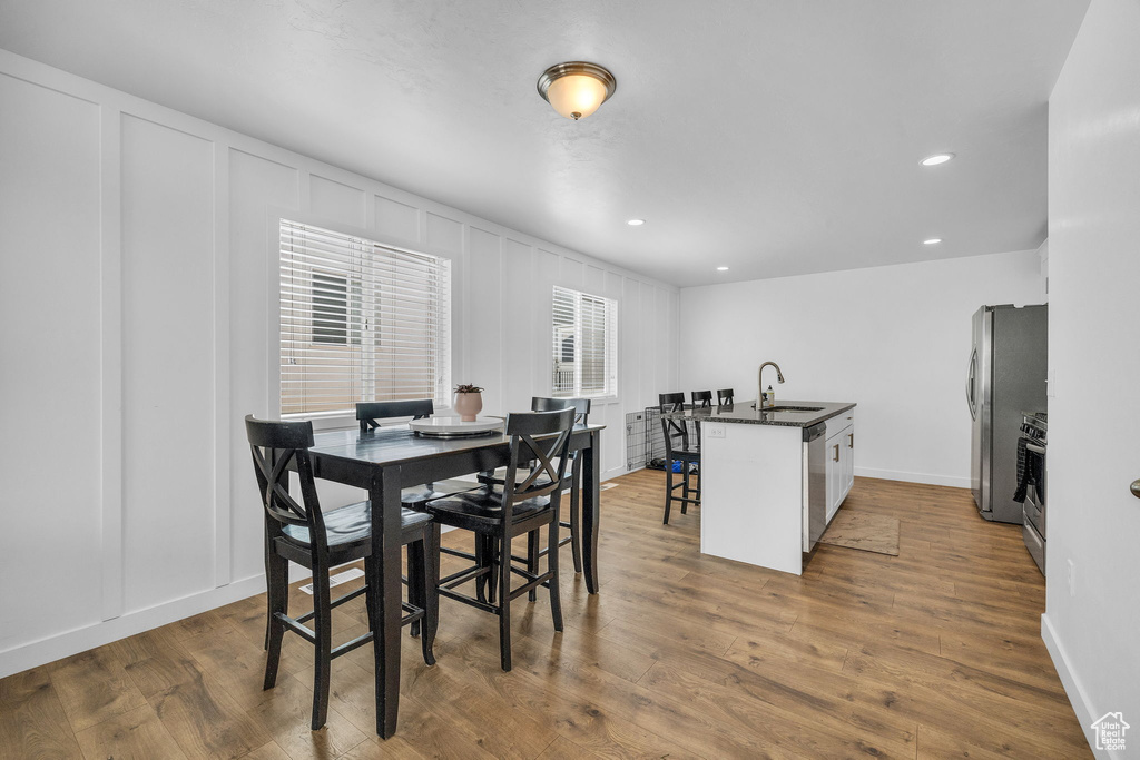 Dining room with hardwood / wood-style flooring and sink