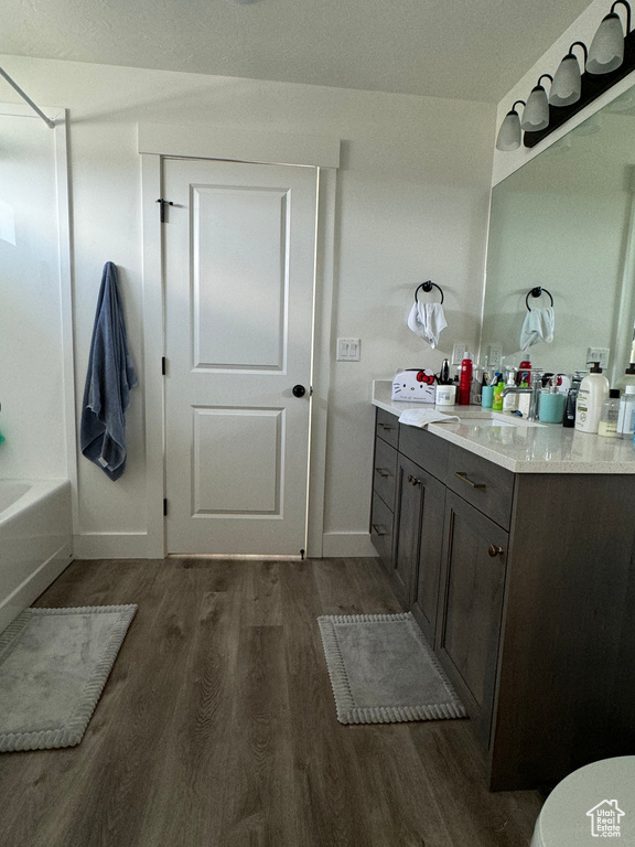 Bathroom featuring wood-type flooring, vanity, and bathing tub / shower combination