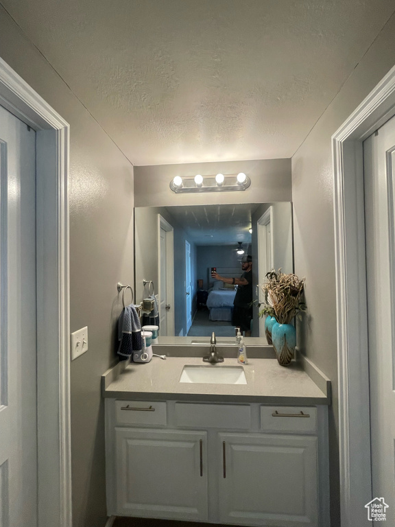Bathroom featuring a textured ceiling and vanity