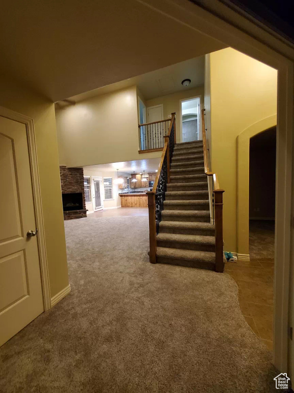 Stairway featuring carpet and a large fireplace
