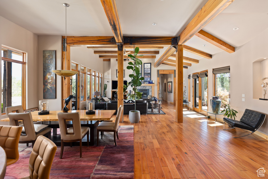 Dining room with lofted ceiling with beams and hardwood / wood-style floors