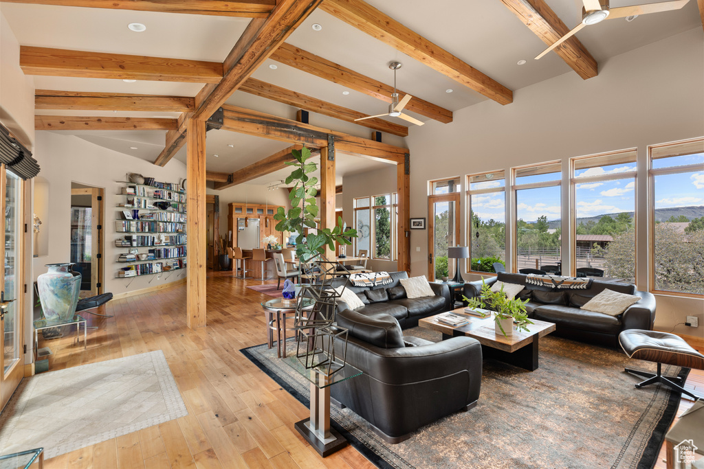 Living room featuring beamed ceiling, light hardwood / wood-style flooring, and ceiling fan