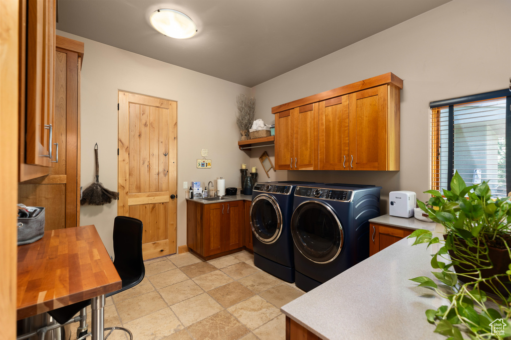 Laundry room featuring sink, cabinets, light tile floors, and separate washer and dryer