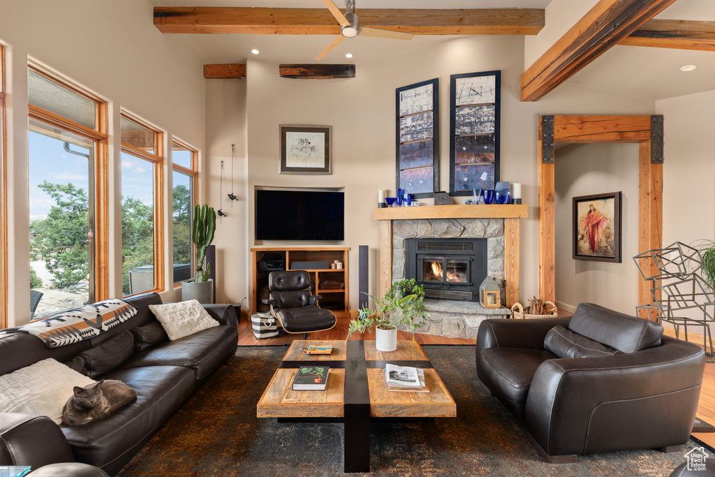 Living room with wood-type flooring, beam ceiling, and a fireplace