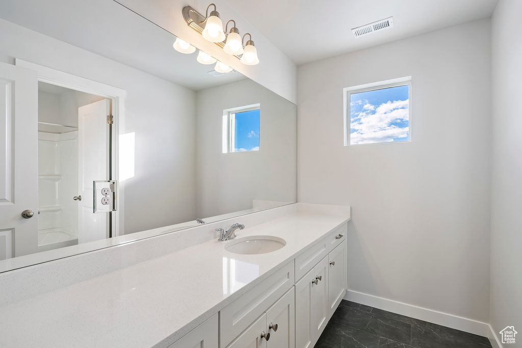 Bathroom with shower / washtub combination, tile floors, and vanity