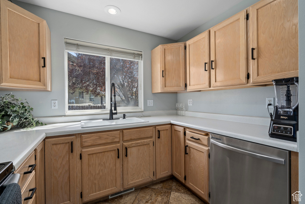 Kitchen featuring range, light brown cabinetry, sink, dishwasher, and tile floors