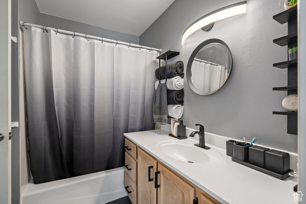 Bathroom with shower / tub combo with curtain and vanity