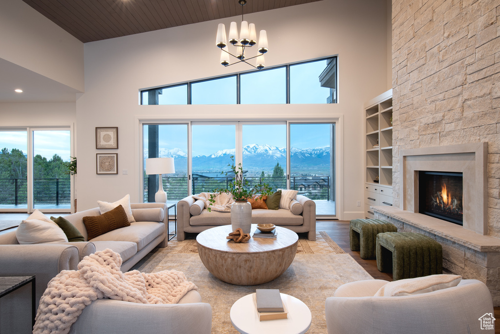 Living room with a mountain view, a fireplace, high vaulted ceiling, hardwood / wood-style floors, and plenty of natural light