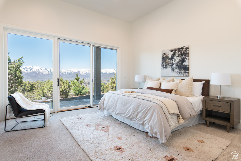 Bedroom featuring a mountain view, carpet flooring, and access to exterior