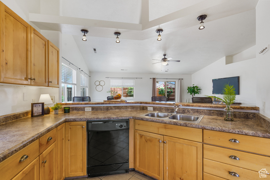 Kitchen featuring ceiling fan, sink, light tile flooring, black dishwasher, and vaulted ceiling