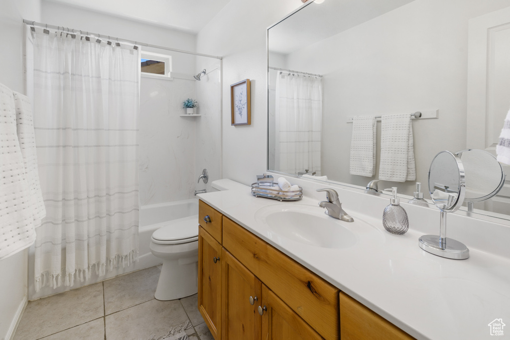 Full bathroom featuring shower / bath combo with shower curtain, toilet, tile flooring, and vanity