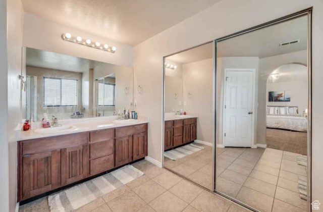 Bathroom with tile floors and dual bowl vanity