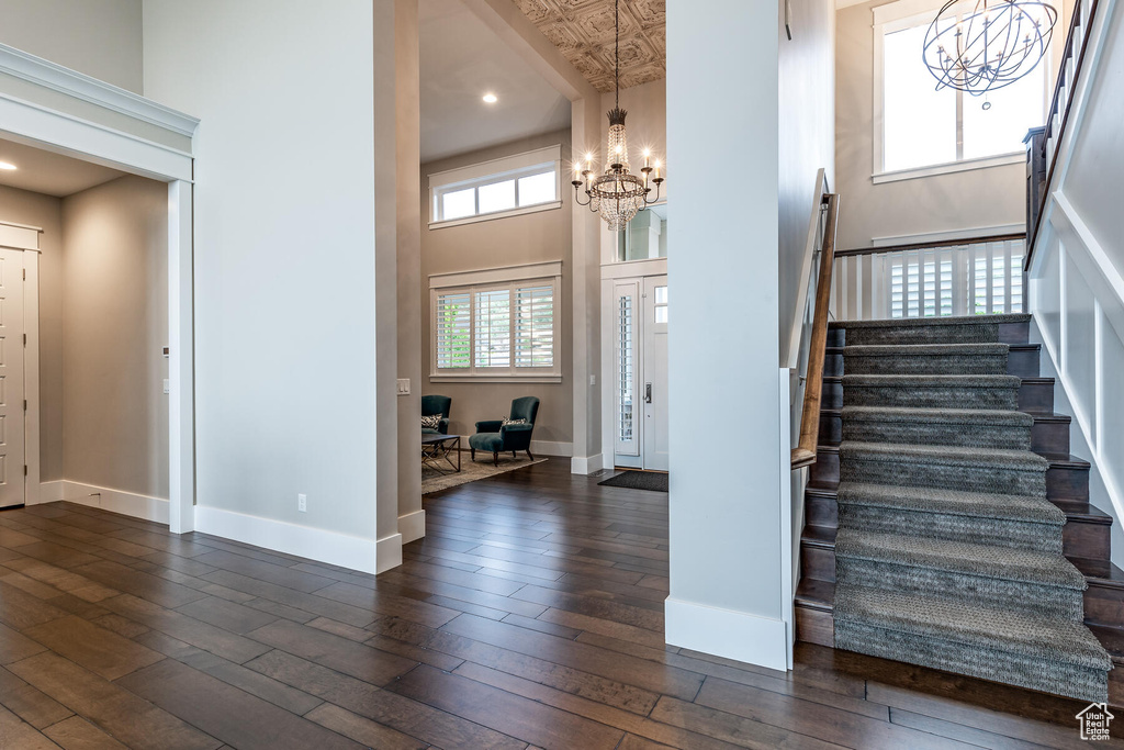 Entrance foyer with a high ceiling, a chandelier, and dark hardwood / wood-style floors