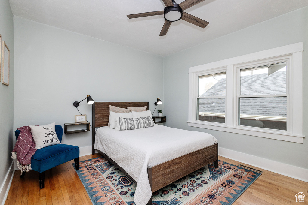 Bedroom with ceiling fan and hardwood / wood-style flooring