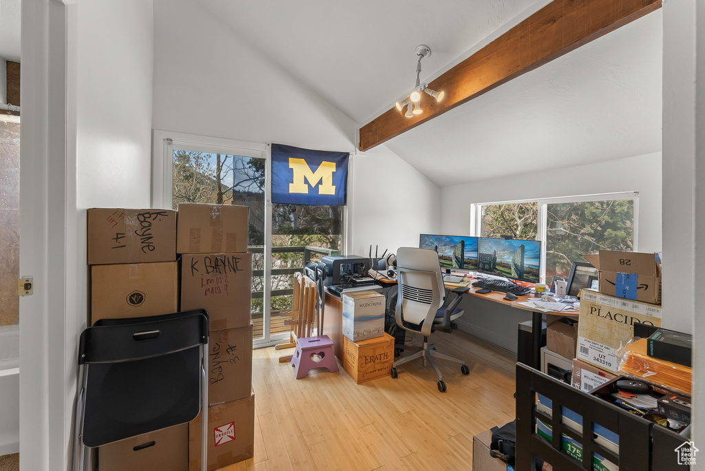 Home office with lofted ceiling with beams, wood-type flooring, and plenty of natural light