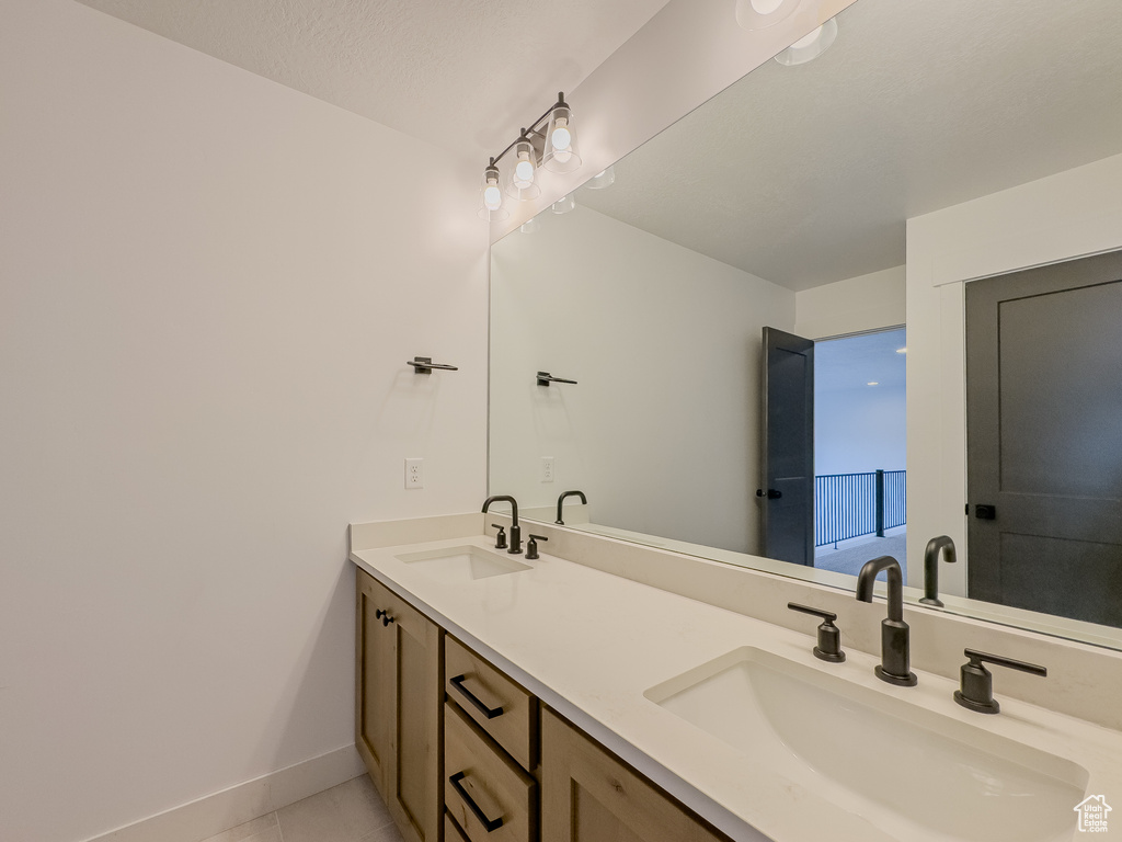 Bathroom with dual bowl vanity and tile flooring